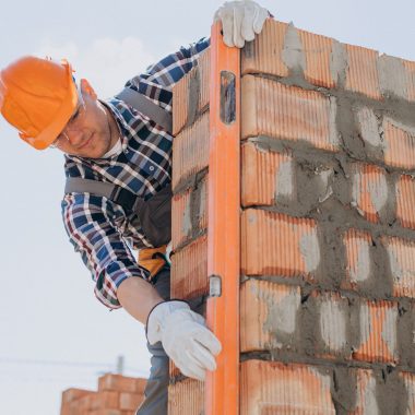 Young craftsman building a house